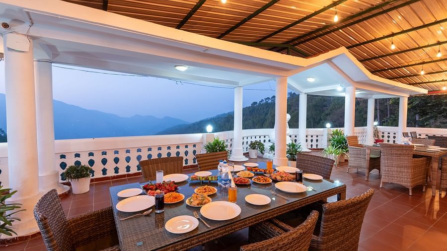 A scenic dining area at DLS Tehri Club Resort with a breathtaking view of the mountains.